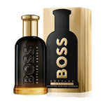 Hugo Boss Bottled Absolu perfume bottle in black with gold detailing, shown next to its matching gold and black packaging box on a white background.